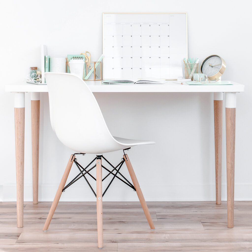 White chair in front of a desk with a calendar