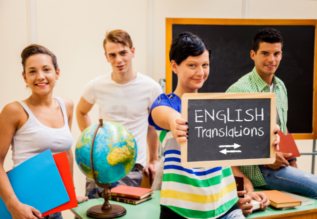 A group of  happy translation students in a classroom study hold a sign that reads "ENGLISH Translations."